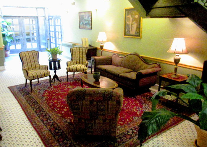 Photo of a lounge area with couch, chairs, a rug, and other decor.